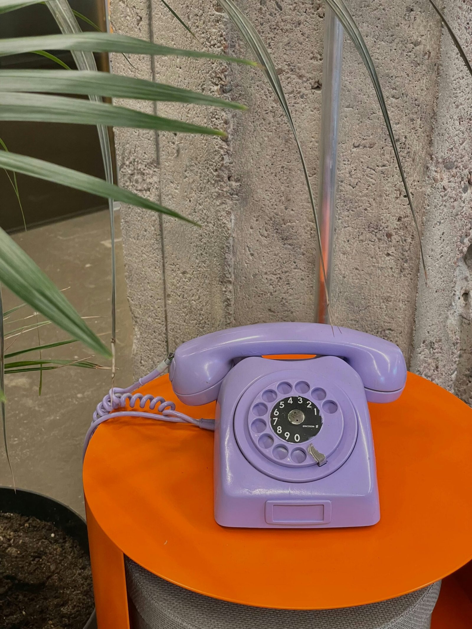 Cute purple telephone on orange table